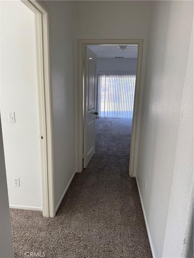 hall featuring dark colored carpet