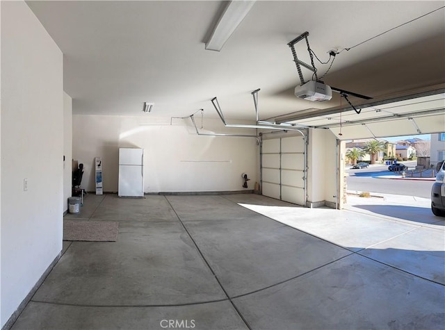 garage featuring a garage door opener and white refrigerator