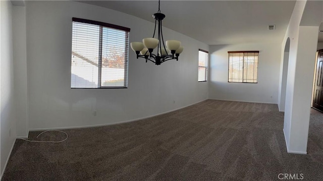 unfurnished dining area featuring dark carpet and an inviting chandelier