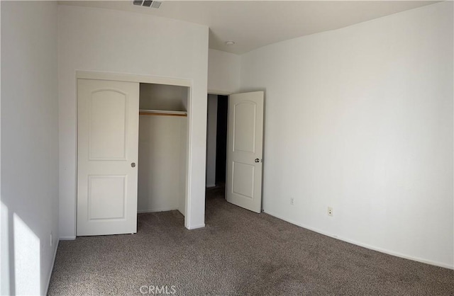 unfurnished bedroom with a closet and carpet flooring