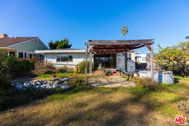 back of house featuring a pergola and a lawn