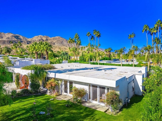 back of house featuring a mountain view, a yard, and a covered pool