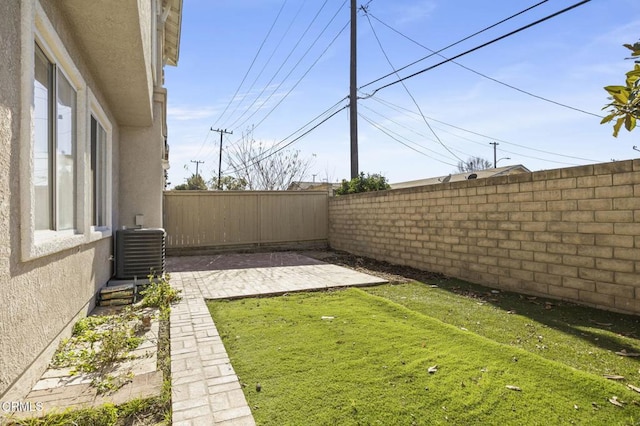 view of yard featuring central AC unit and a patio area