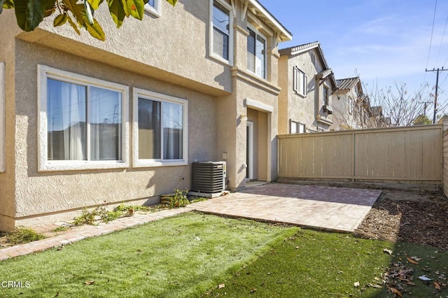 exterior space featuring cooling unit, a lawn, and a patio