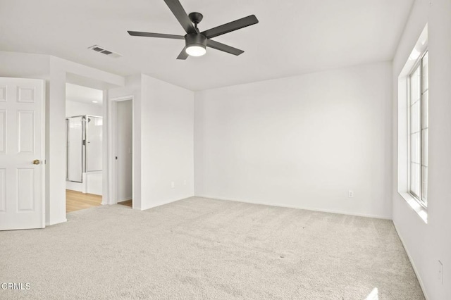 carpeted empty room featuring ceiling fan and a wealth of natural light