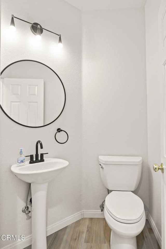 bathroom with toilet, hardwood / wood-style flooring, and sink