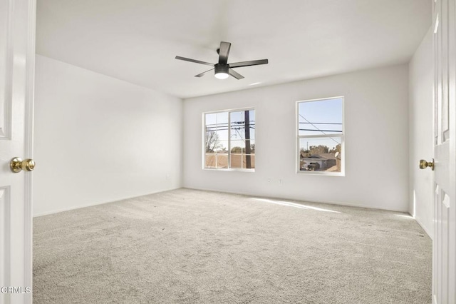 carpeted spare room with ceiling fan