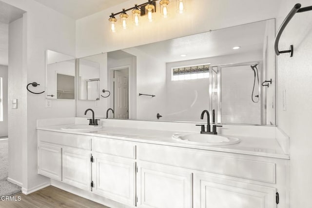 bathroom with a shower with shower door, wood-type flooring, and vanity