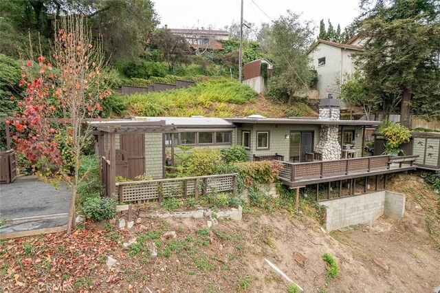 back of property featuring a wooden deck and a storage shed