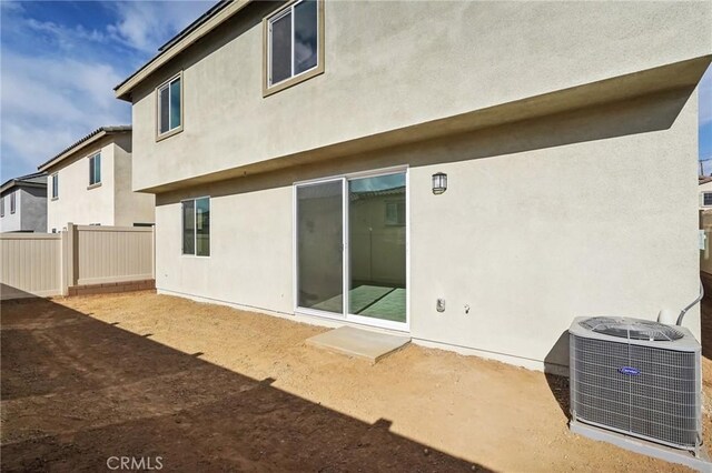 back of house with central AC unit