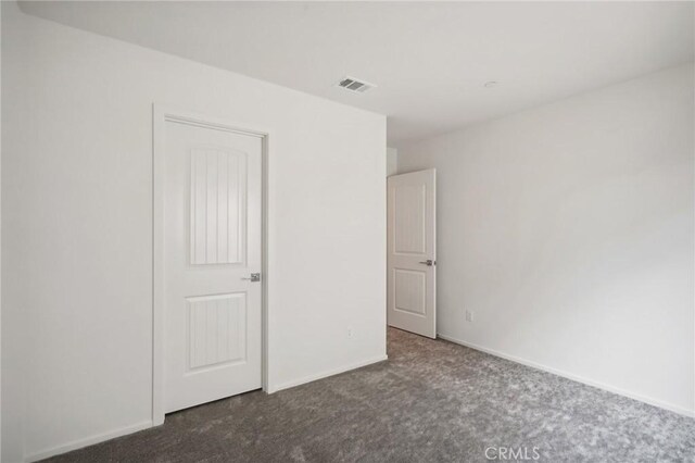 unfurnished bedroom featuring dark colored carpet