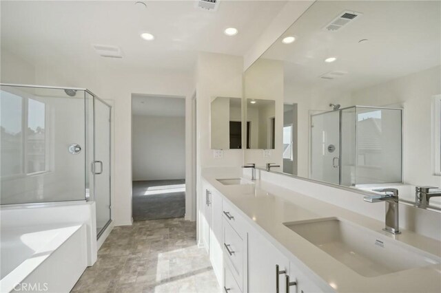 bathroom featuring vanity and independent shower and bath