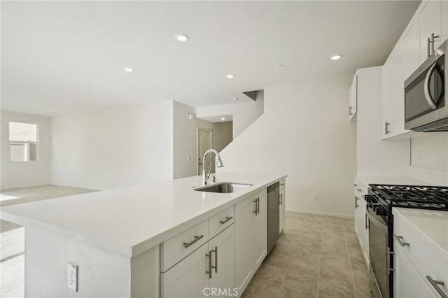 kitchen featuring appliances with stainless steel finishes, sink, white cabinetry, and an island with sink