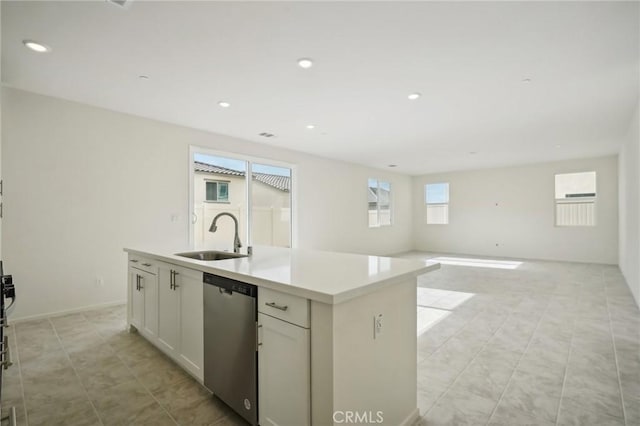 kitchen featuring dishwasher, white cabinetry, an island with sink, sink, and light tile patterned floors