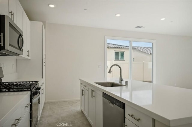 kitchen with a center island with sink, appliances with stainless steel finishes, white cabinets, and sink