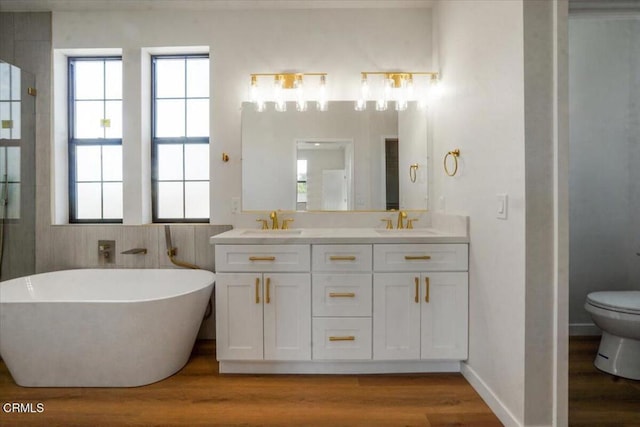 full bathroom with hardwood / wood-style flooring, toilet, separate shower and tub, and vanity