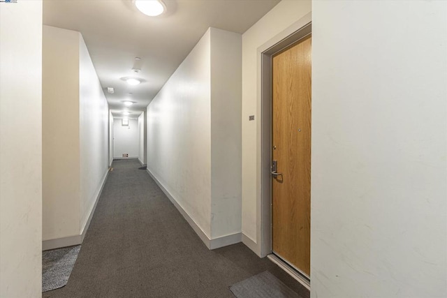 hallway featuring dark carpet