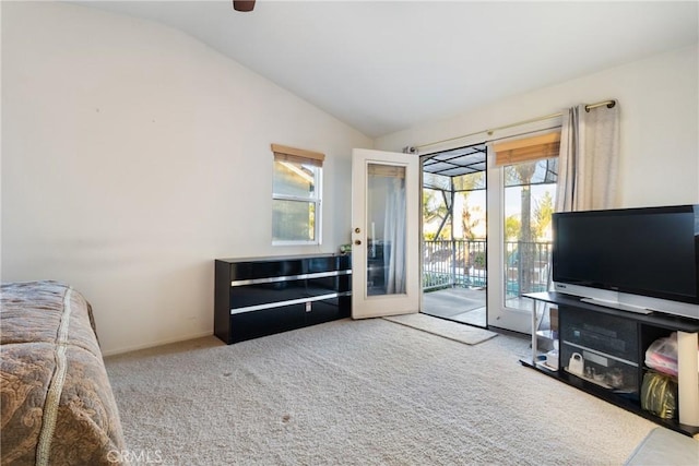 carpeted living room featuring vaulted ceiling and french doors