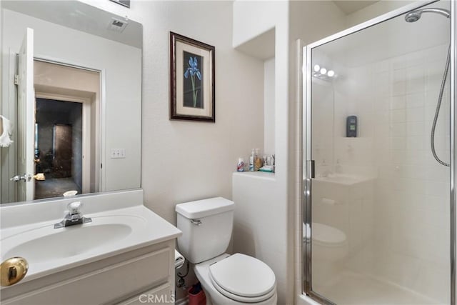 bathroom featuring toilet, an enclosed shower, and vanity