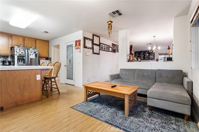 living room featuring an inviting chandelier and light hardwood / wood-style floors