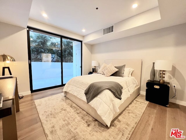 bedroom featuring access to exterior and light hardwood / wood-style flooring