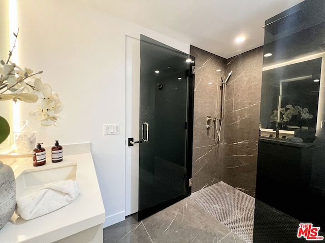 bathroom with a shower with door and vanity