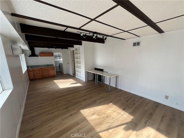 unfurnished living room with a drop ceiling and light hardwood / wood-style floors