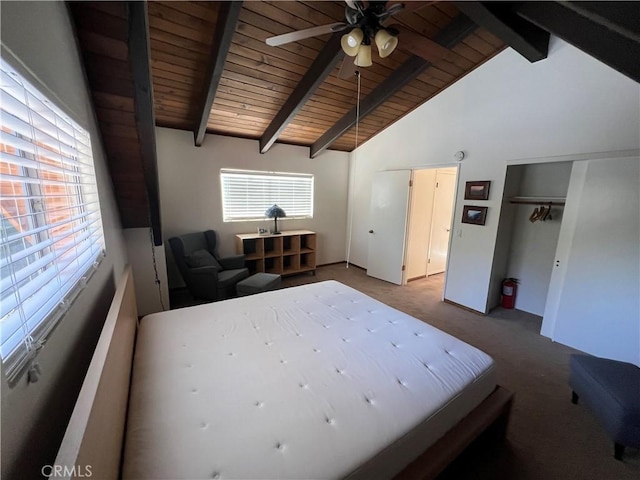 unfurnished bedroom with carpet, beamed ceiling, a closet, ceiling fan, and wooden ceiling