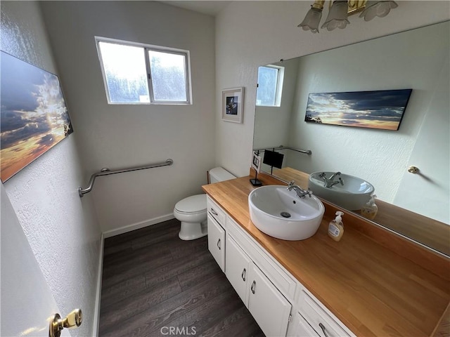 bathroom with toilet, vanity, and wood-type flooring