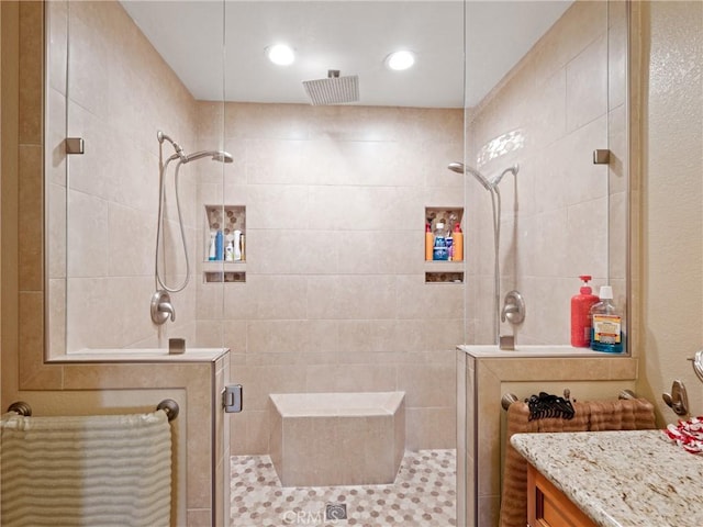 bathroom with a shower with shower door and vanity