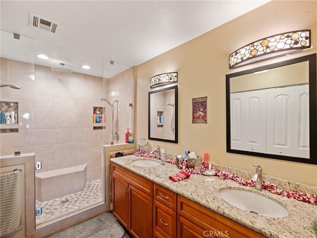 bathroom with vanity and a shower with door