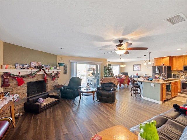 living room featuring a fireplace, ceiling fan, light hardwood / wood-style floors, and beverage cooler