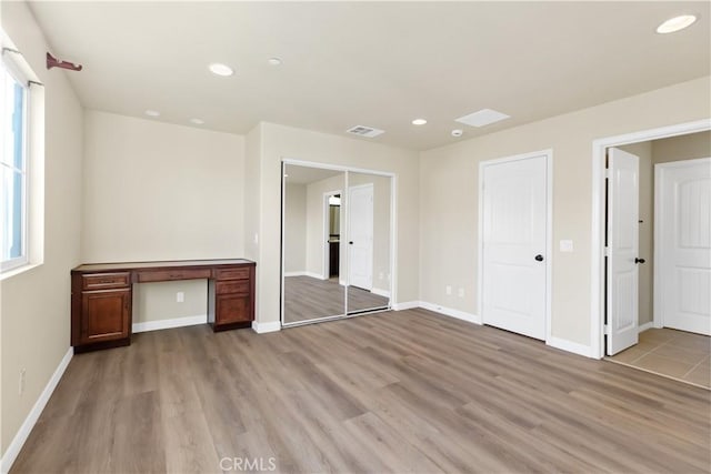 unfurnished bedroom with multiple windows and light wood-type flooring