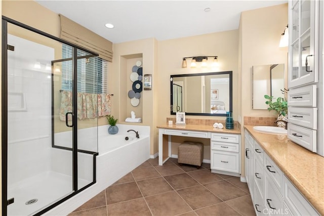 bathroom with plus walk in shower, tile patterned floors, and vanity