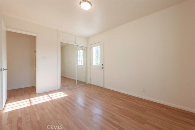 unfurnished bedroom with a closet and light hardwood / wood-style floors