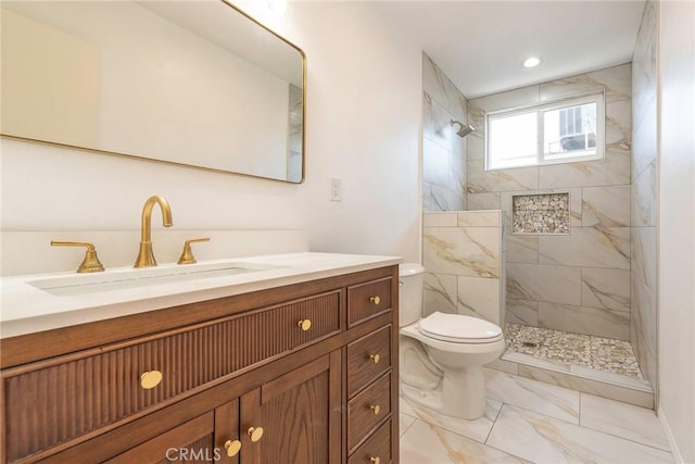 bathroom featuring toilet, vanity, and a tile shower