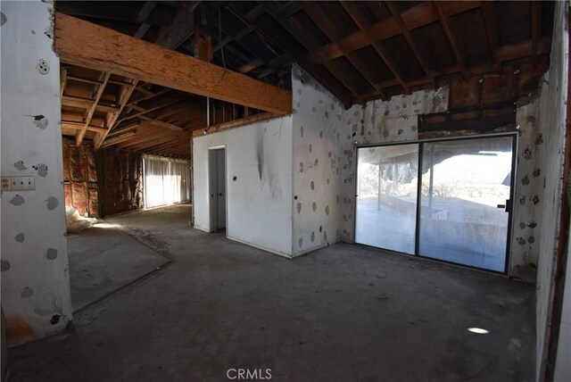 miscellaneous room featuring vaulted ceiling and concrete floors