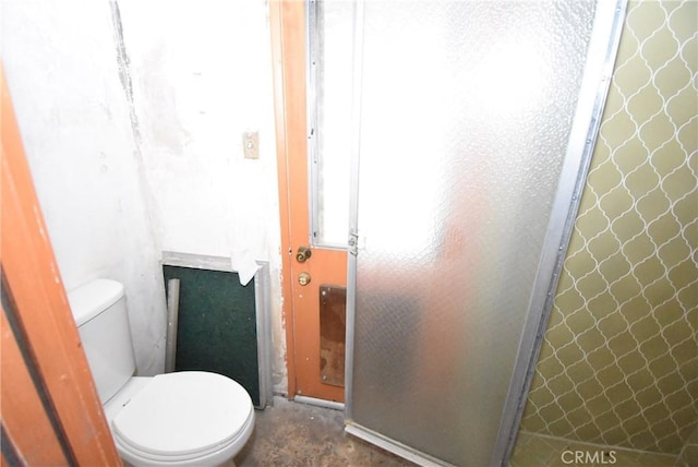 bathroom featuring toilet and an enclosed shower