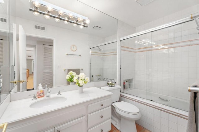 full bathroom with toilet, vanity, and enclosed tub / shower combo