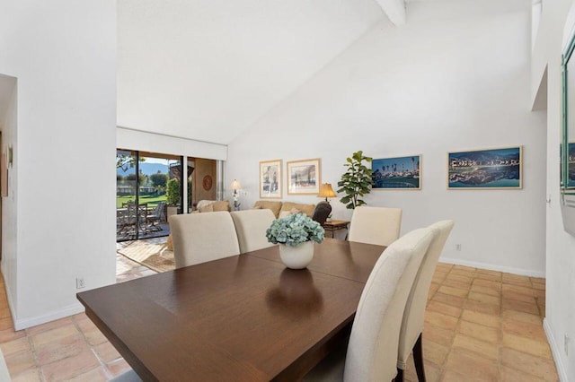 dining room featuring beam ceiling and high vaulted ceiling