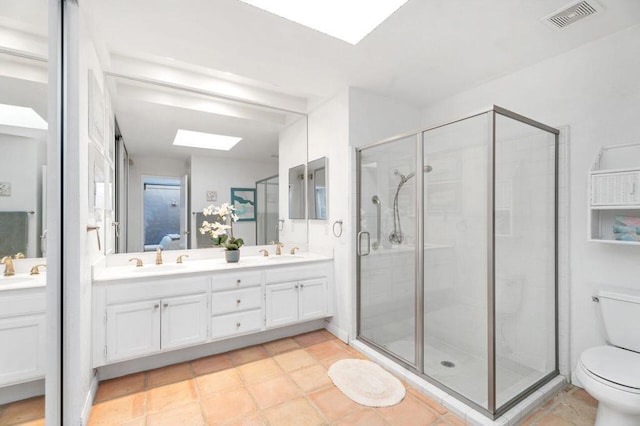 bathroom featuring an enclosed shower, vanity, a skylight, and tile patterned flooring