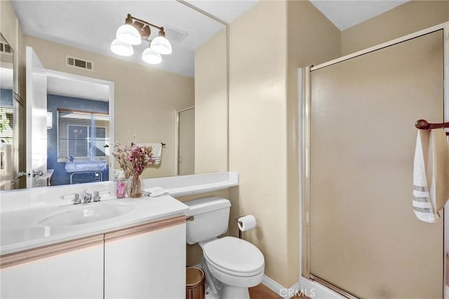 bathroom with toilet, vanity, and a shower with door