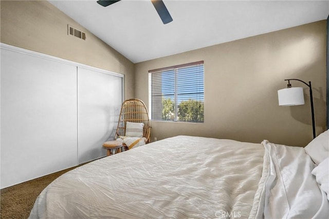 bedroom with ceiling fan, a closet, lofted ceiling, and carpet floors