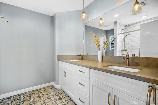 bathroom featuring a tile shower, tile patterned floors, and vanity