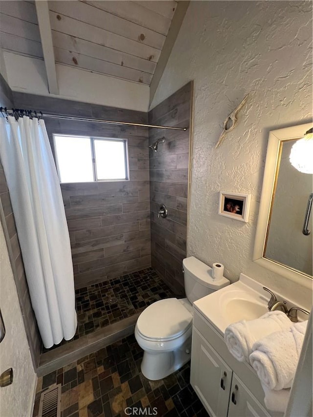 bathroom featuring toilet, vanity, lofted ceiling with beams, and curtained shower