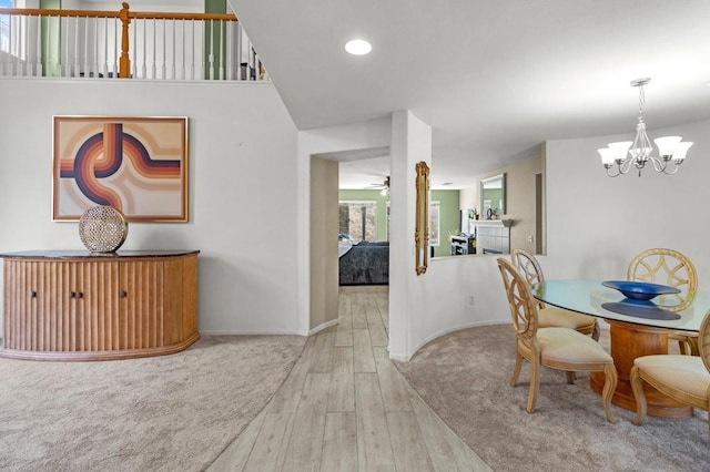 dining room with ceiling fan with notable chandelier and light wood-type flooring