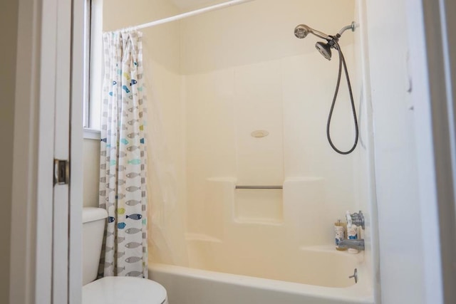 bathroom featuring shower / bath combo with shower curtain and toilet