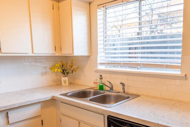 kitchen featuring sink, backsplash, and dishwasher