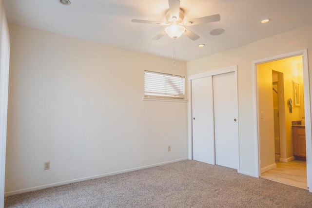 unfurnished bedroom featuring light carpet, a closet, and ceiling fan