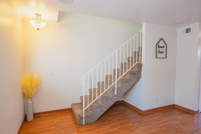 staircase with hardwood / wood-style floors